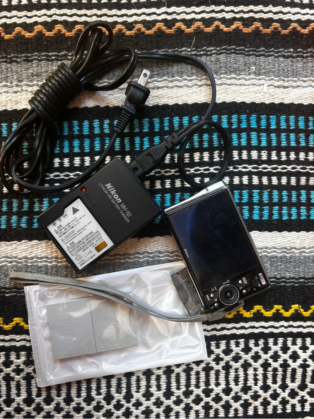 Three NEW lithium ion batteries; used charger for Nikon Coolpix camera.